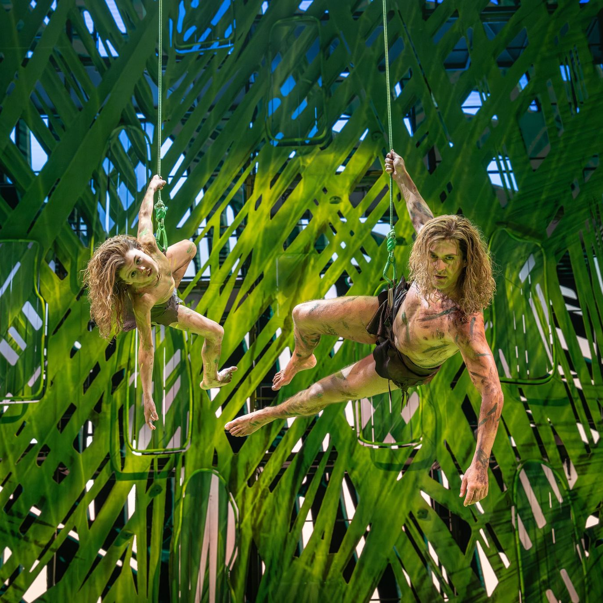 Vater und Sohn schwingen sich an Lianen durch den Dschungel. - Foto: Johan Persson/Stage Entertainment/dpa