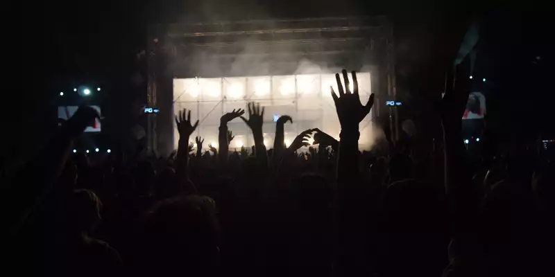 Nacht voller Energie: Vor der gleißend weißen Festivalbühne tauchen unzählige Hände aus dem Dunkel in den aufsteigenden Nebel. - Foto: THN