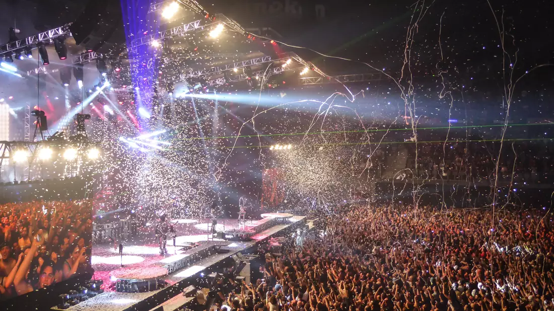 Arena-Konzert mit Konfetti, Luftschlangen, Lichtshow und großer Menschenmenge