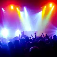 Farbenrausch auf dem Dancefloor: Hinter dem Pult treibt der DJ die Menge an, eingerahmt von einem Wirbel aus bunten Strahlen. - Foto: THN