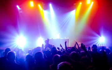 Farbenrausch auf dem Dancefloor: Hinter dem Pult treibt der DJ die Menge an, eingerahmt von einem Wirbel aus bunten Strahlen. - Foto: THN