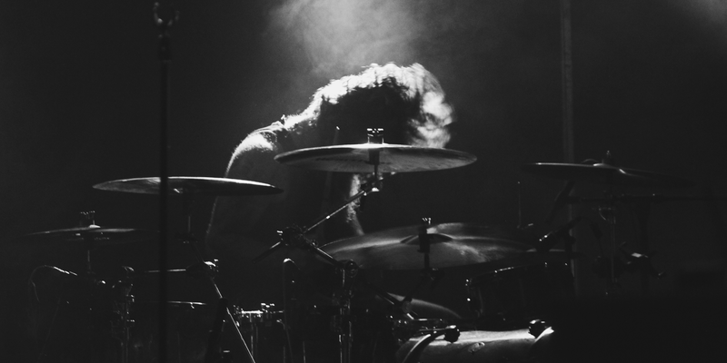 Hingabe in Schwarzweiß: Tief über das Drumset gebeugt verschwindet der Schlagzeuger fast im hellen Lichtkegel von oben. - Foto: THN