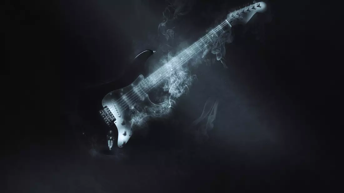 E-Gitarre umhüllt von Rauch vor schwarzem Hintergrund in geheimnisvollem Licht