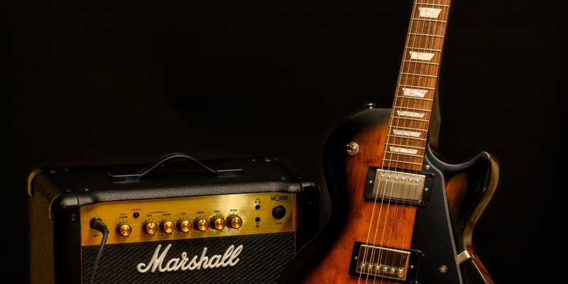 Klassisches Gespann: Eine Sunburst-Gitarre steht neben einem kompakten Combo-Verstärker und wartet auf den ersten Akkord. - Foto: THN