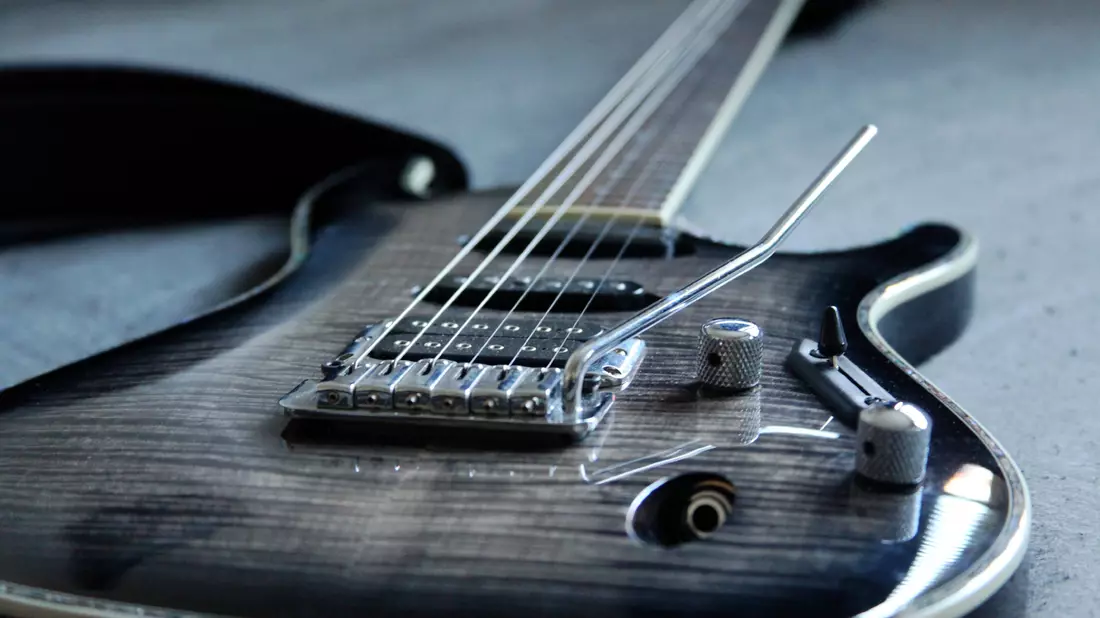 Detailaufnahme einer grau gemaserten E-Gitarre mit Tonabnehmern und Tremolohebel