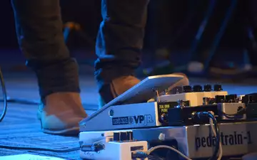 Steuerung am Boden: Der Fuß des Musikers betätigt das Volumenpedal, umgeben von einem Setup aus weiteren Effektgeräten. - Foto: THN