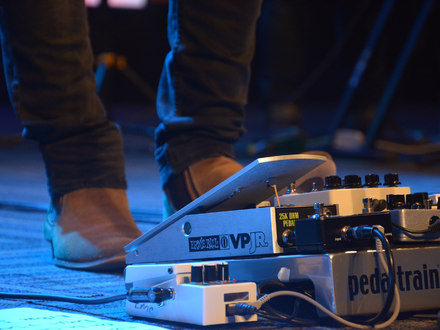 Steuerung am Boden: Der Fuß des Musikers betätigt das Volumenpedal, umgeben von einem Setup aus weiteren Effektgeräten. - Foto: THN