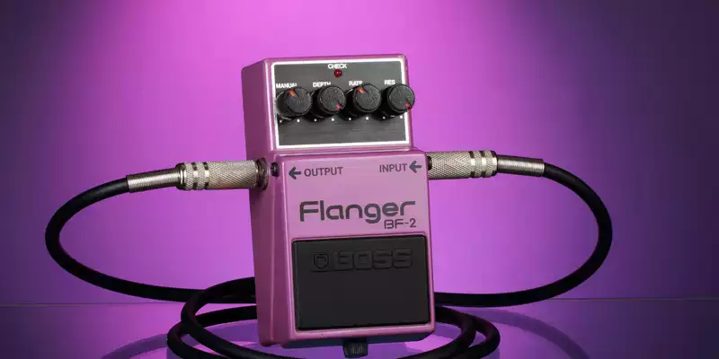 Klangformer im Fokus: Ein lila Flanger-Effektpedal mit eingesteckten Kabeln präsentiert sich vor passend violettem Hintergrund. - Foto: THN