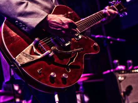 Vintage-Sound in Rot: Die Hände des Gitarristen führen die rote Halbresonanzgitarre samt Vibratohebel durch den Song. - Foto: THN