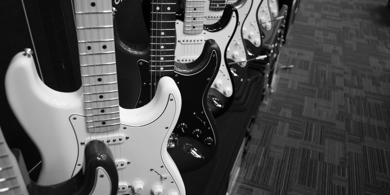 Qual der Wahl: Dicht an dicht reihen sich zahlreiche E-Gitarren auf, festgehalten in stimmungsvollem Schwarzweiß im Musikladen. - Foto: THN