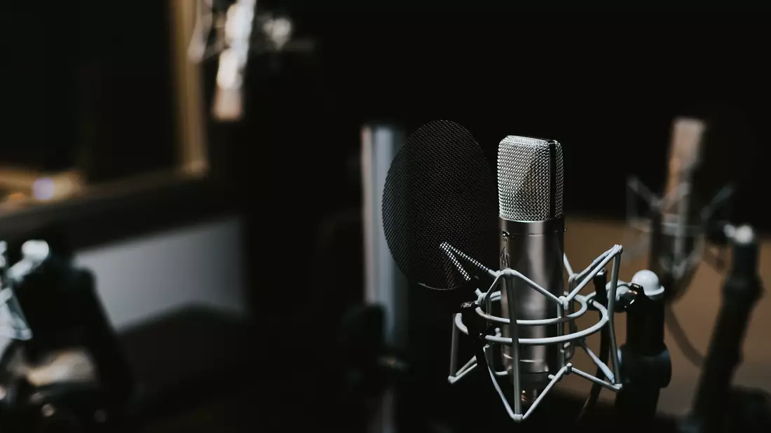 Kondensatormikrofon mit Spinne und Popschutz im abgedunkelten Tonstudio