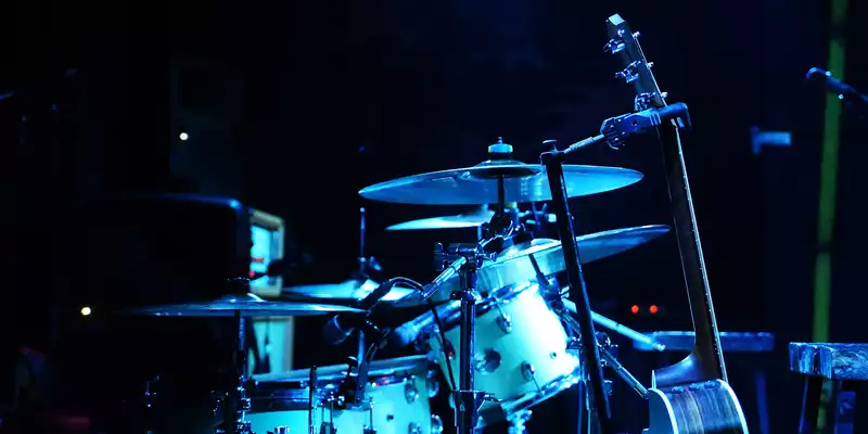 Kühle Eleganz: In tiefes Blau getaucht steht das komplette Drumset mit seinen Becken bereit auf der dunklen Konzertbühne. - Foto: THN