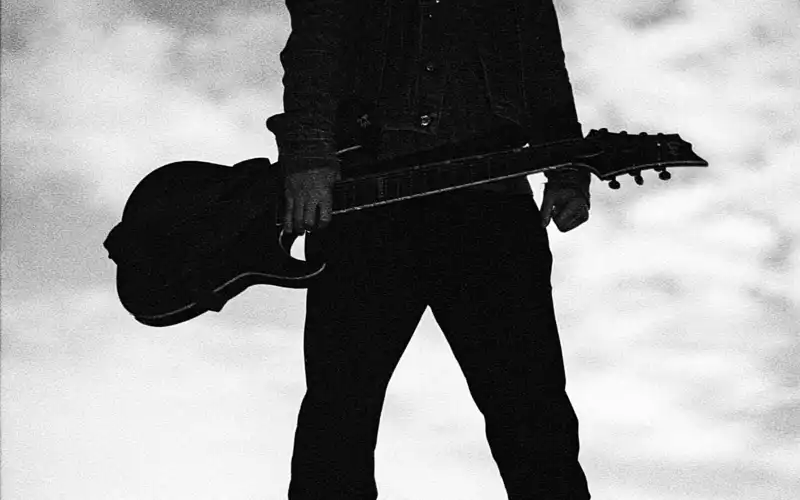 Einsame Pose im Gegenlicht: Mit der Gitarre in der Hand steht der Musiker als markante Silhouette vor dem bewölkten Himmel. - Foto: THN