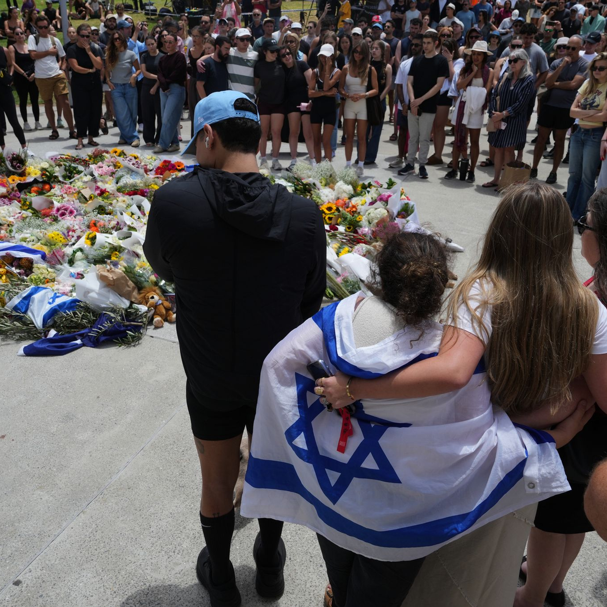 Zahlreiche Menschen legen am Tatort Blumen nieder.   - Foto: Mark Baker/AAP/dpa