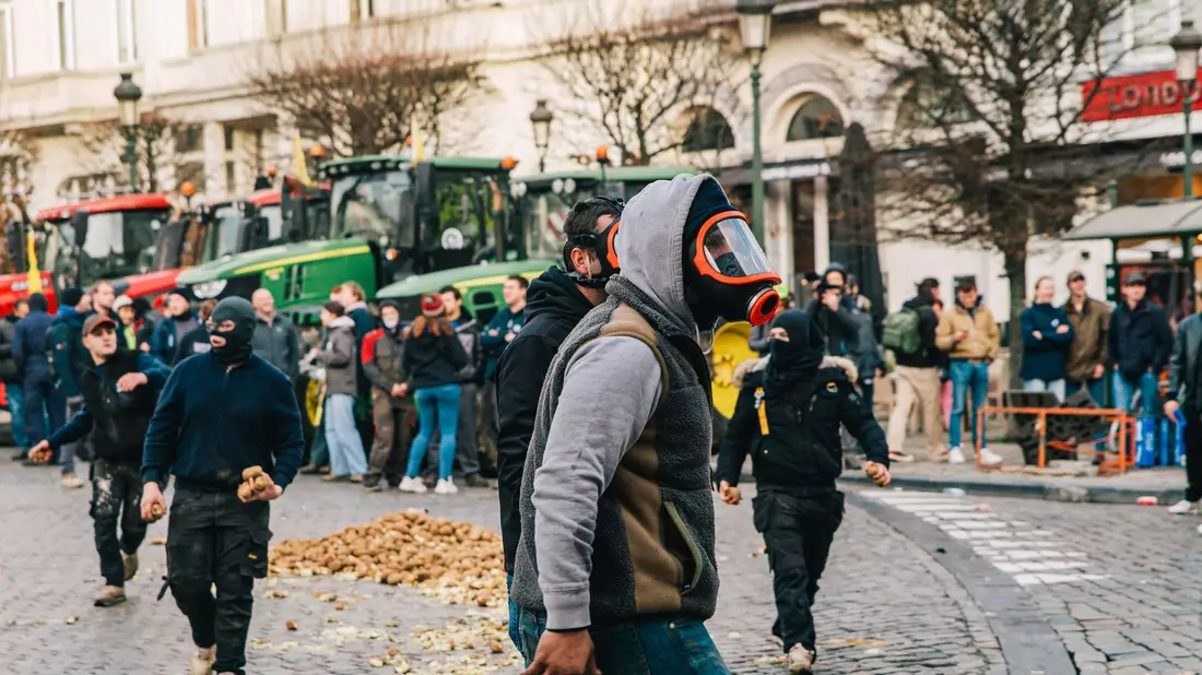 Demonstranten und Bereitschaftspolizei stehen vor dem Eingang des Europäischen Parlaments. - Bild: Emile Windal/Belga/dpa