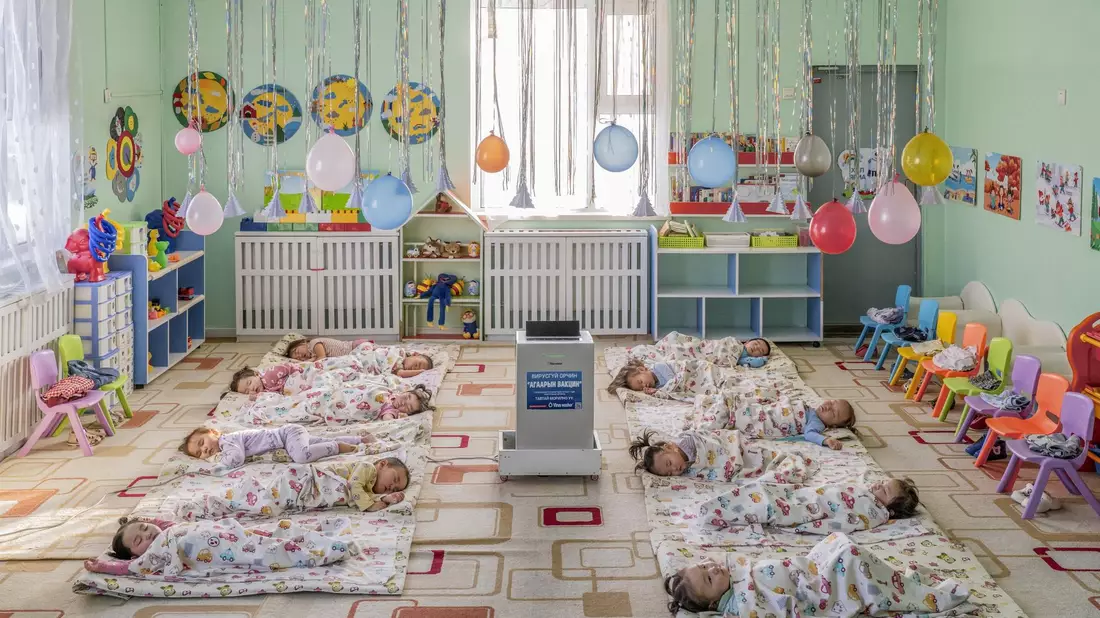 In einem Kindergarten in Ulaanbaatar, der Hauptstadt der Mongolei, liegen Kinder auf dem Boden um einen aufgestellten Luftfilter herum, der die Schadstoffkonzentration senken soll. - Bild: Natalya Saprunova/Unicef/dpa