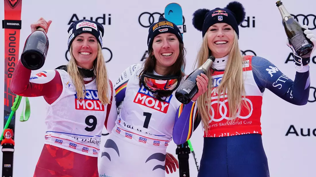 Neben Siegerin Hütter (links) und der drittplatzierten Vonn (rechts) lässt es sich gut feiern. - Bild: Pier Marco Tacca/AP/dpa
