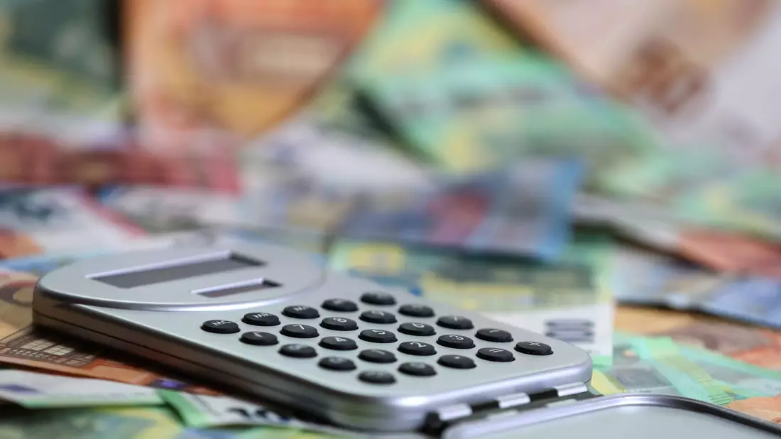 Ein Taschenrechner liegt auf verschiedenen Euro-Banknoten. (Symbolbild) - Bild: Karl-Josef Hildenbrand/dpa