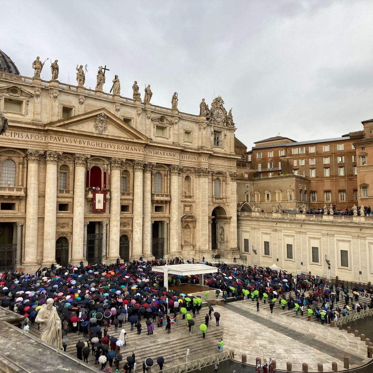 Mit Regencapes und unter Regenschirmen verfolgten die Gläubingen die Ansprache des Papstes. - Foto: Sabine Dobel/dpa