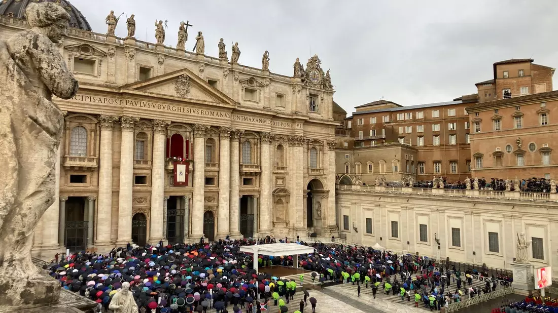 Mit Regencapes und unter Regenschirmen verfolgten die Gläubingen die Ansprache des Papstes. - Bild: Sabine Dobel/dpa