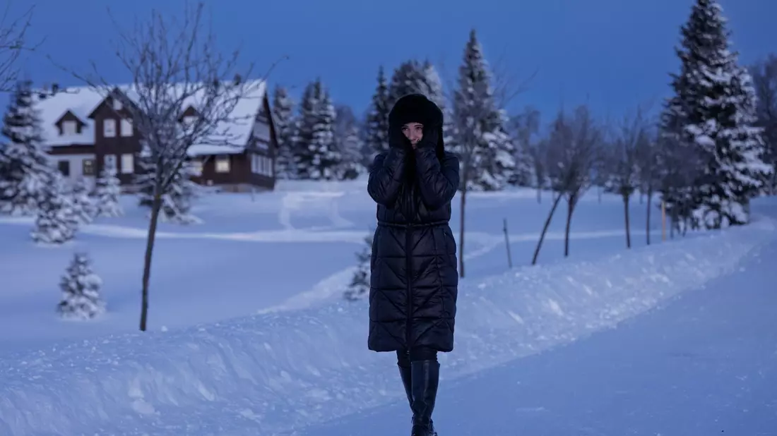 Eine Frau spaziert durch eine verschneite Landschaft in Tschechien. - Bild: Radek Petrášek/CTK/dpa
