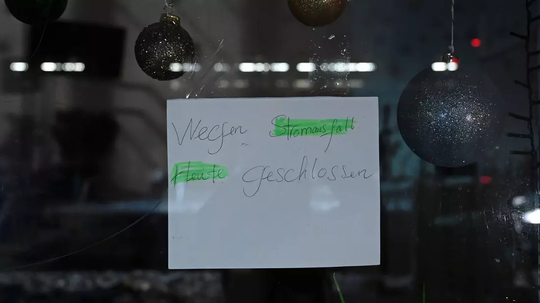 In einem Schaufenster in Zehlendorf hängt ein Schild mit dem Hinweis, dass derzeit wegen Stromausfall kein Ladenbetrieb stattfindet. - Bild: Elisa Schu/dpa