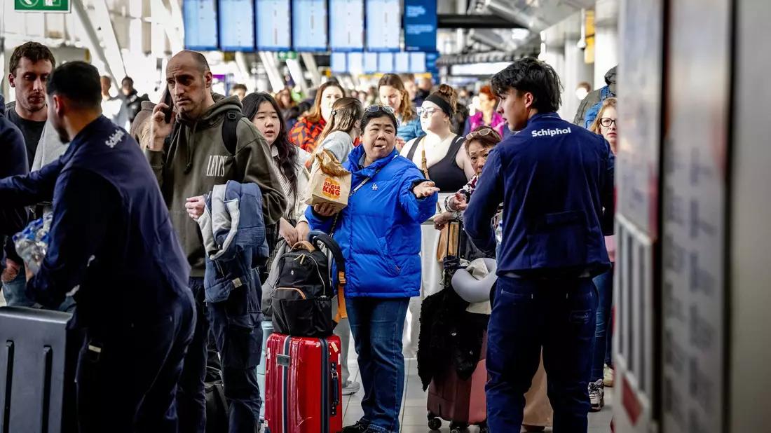 Reisende stehen Schlange am Serviceschalter der Fluggesellschaft KLM am Flughafen Schiphol.  - Bild: Robin Utrecht/ANP/dpa