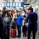 Reisende stehen Schlange am Serviceschalter der Fluggesellschaft KLM am Flughafen Schiphol.  - Foto: Robin Utrecht/ANP/dpa