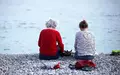 Alte und junge Frau sitzen am Strand - Foto: via dts Nachrichtenagentur