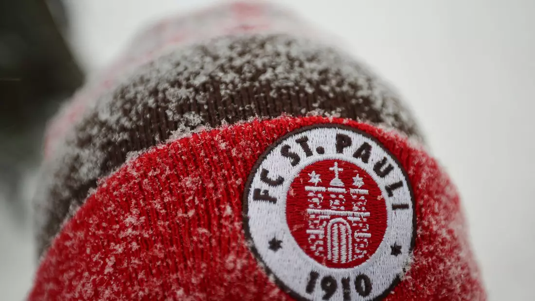 Fans des FC St. Pauli müssen sich am Samstag nicht dem Schnee aussetzen, um ihr Team zu unterstützen. Das abgesagte Spiel wird demnächst nachgeholt. - Bild: Christian Charisius/dpa