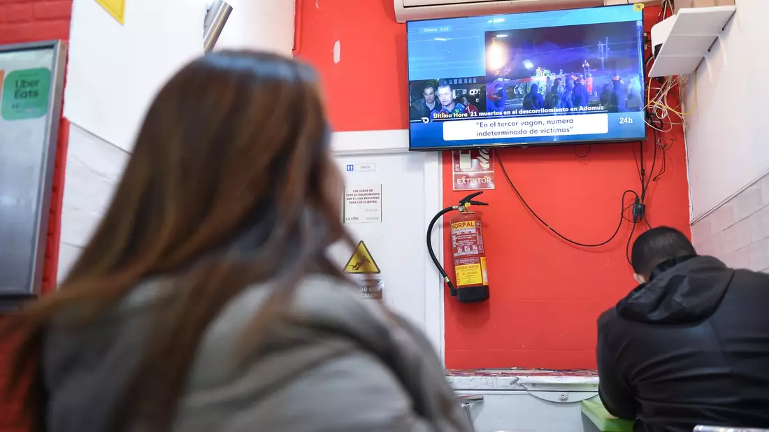 Menschen verfolgten die Berichte über das Unglück vor dem Fernseher. - Bild: Gustavo Valiente/XinHua/dpa