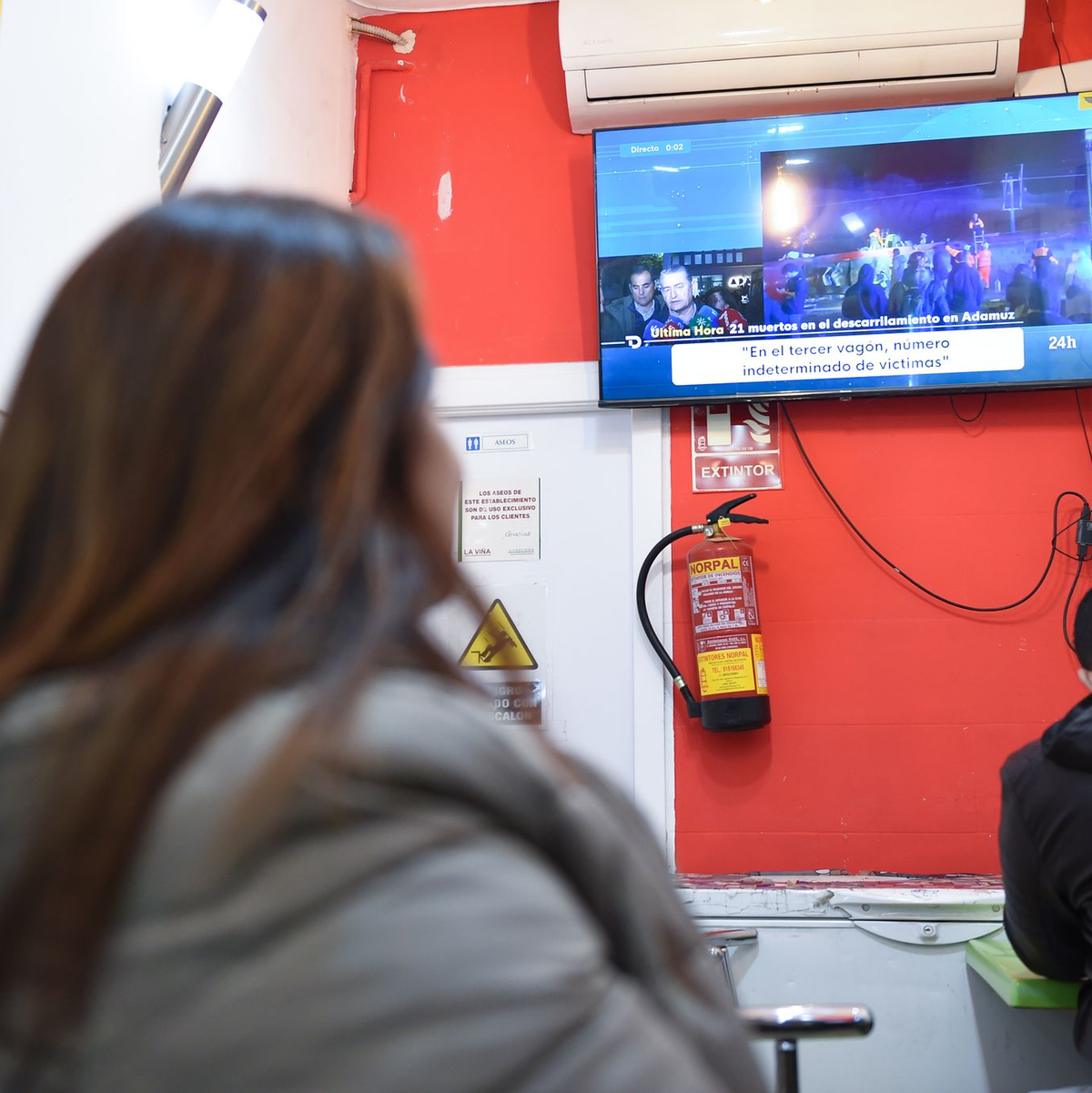 Menschen verfolgten die Berichte über das Unglück vor dem Fernseher. - Foto: Gustavo Valiente/XinHua/dpa