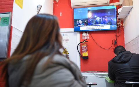 Menschen verfolgten die Berichte über das Unglück vor dem Fernseher. - Foto: Gustavo Valiente/XinHua/dpa