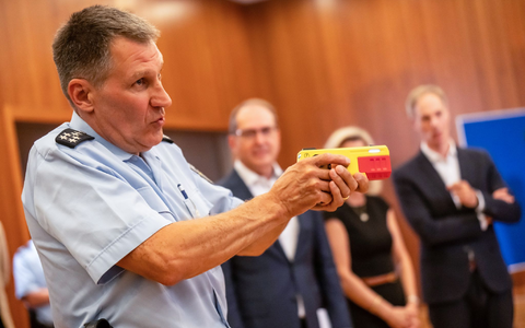 Ein Polizist erklärte die Funktionsweise eines Distanz-Elektroimpulsgeräts im vergangenen Jahr im Innnenministerium. (Archivfoto) - Foto: Michael Kappeler/dpa