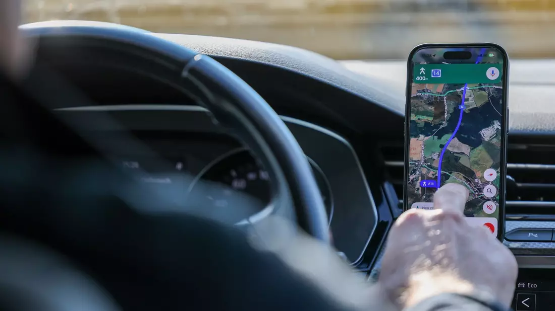 So ist es derzeit erlaubt: Das Handy steckt in der Halterung und wird nur kurz vom Fahrer beachtet. (Symbolbild) - Bild: Jan Woitas/dpa