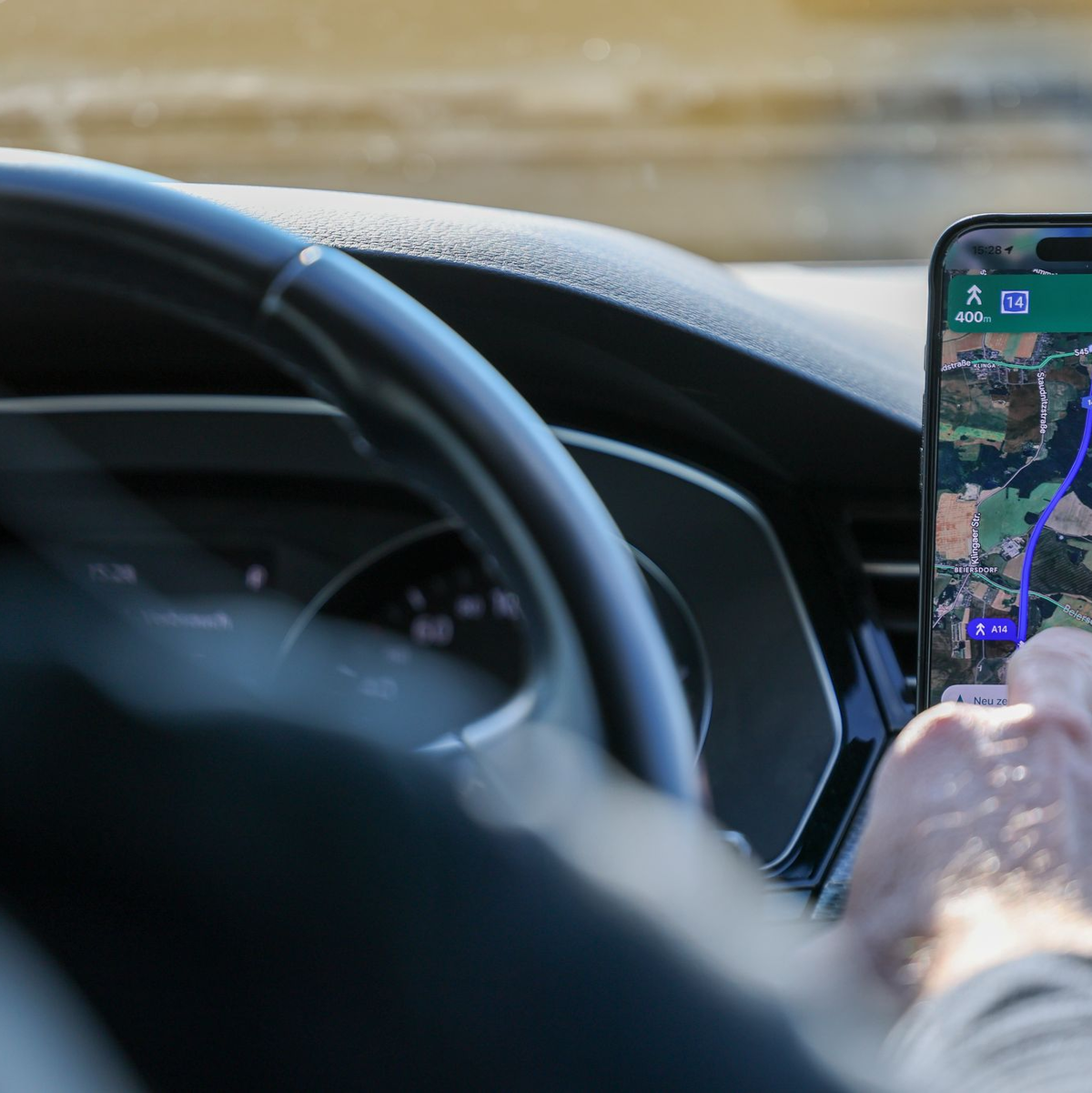 So ist es derzeit erlaubt: Das Handy steckt in der Halterung und wird nur kurz vom Fahrer beachtet. (Symbolbild) - Foto: Jan Woitas/dpa