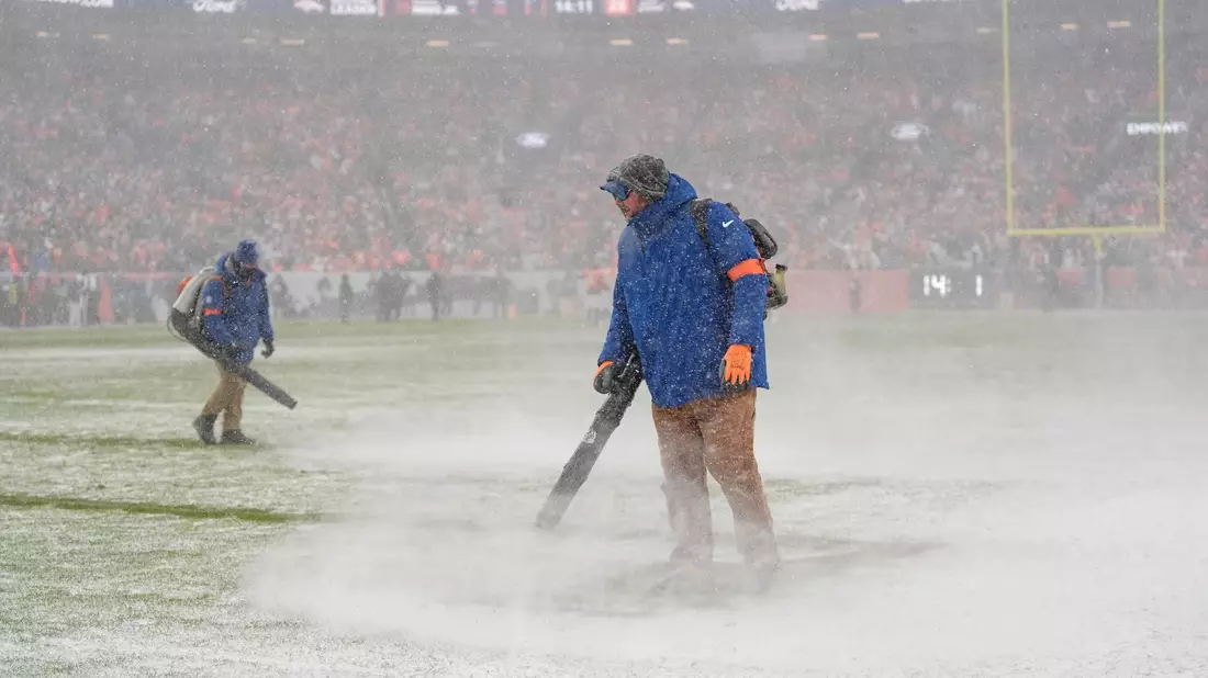 Helfer versuchten die Markierungslinien vom Schnee freizuhalten. - Bild: Ashley Landis/AP/dpa