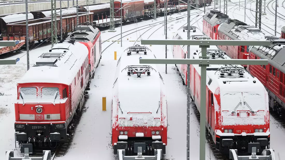 Im Bahnhof in Halle an der Saale sind die Lokomotiven mit Schnee bedeckt. - Bild: Hendrik Schmidt/dpa