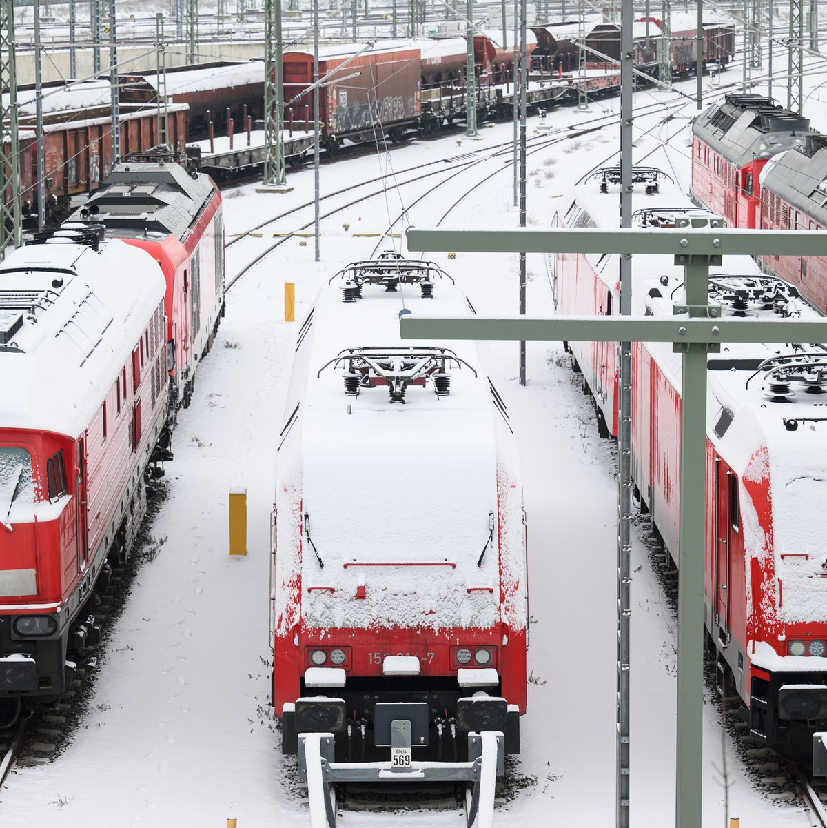 Im Bahnhof in Halle an der Saale sind die Lokomotiven mit Schnee bedeckt. - Foto: Hendrik Schmidt/dpa