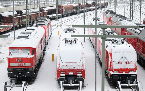Im Bahnhof in Halle an der Saale sind die Lokomotiven mit Schnee bedeckt. - Foto: Hendrik Schmidt/dpa