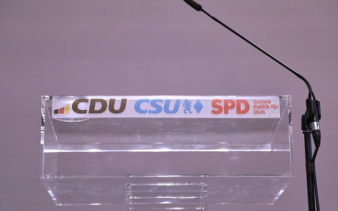 Rednerpult mit den Logos von CDU, CSU und SPD (Archiv) - Foto: via dts Nachrichtenagentur