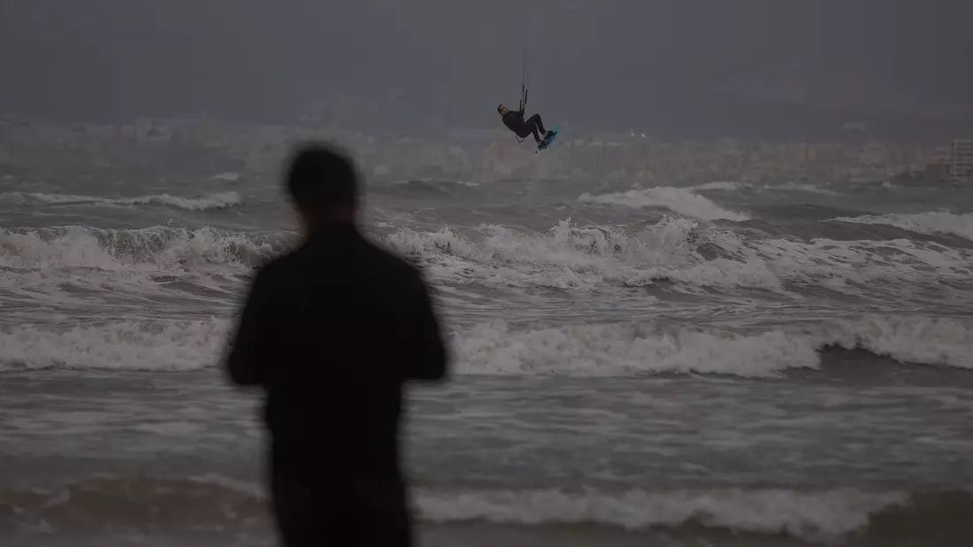 Nicht gerade gemütliches Strandwetter auf Mallorca, aber ideale Bedingungen für Kitesurfer. - Bild: Clara Margais/dpa