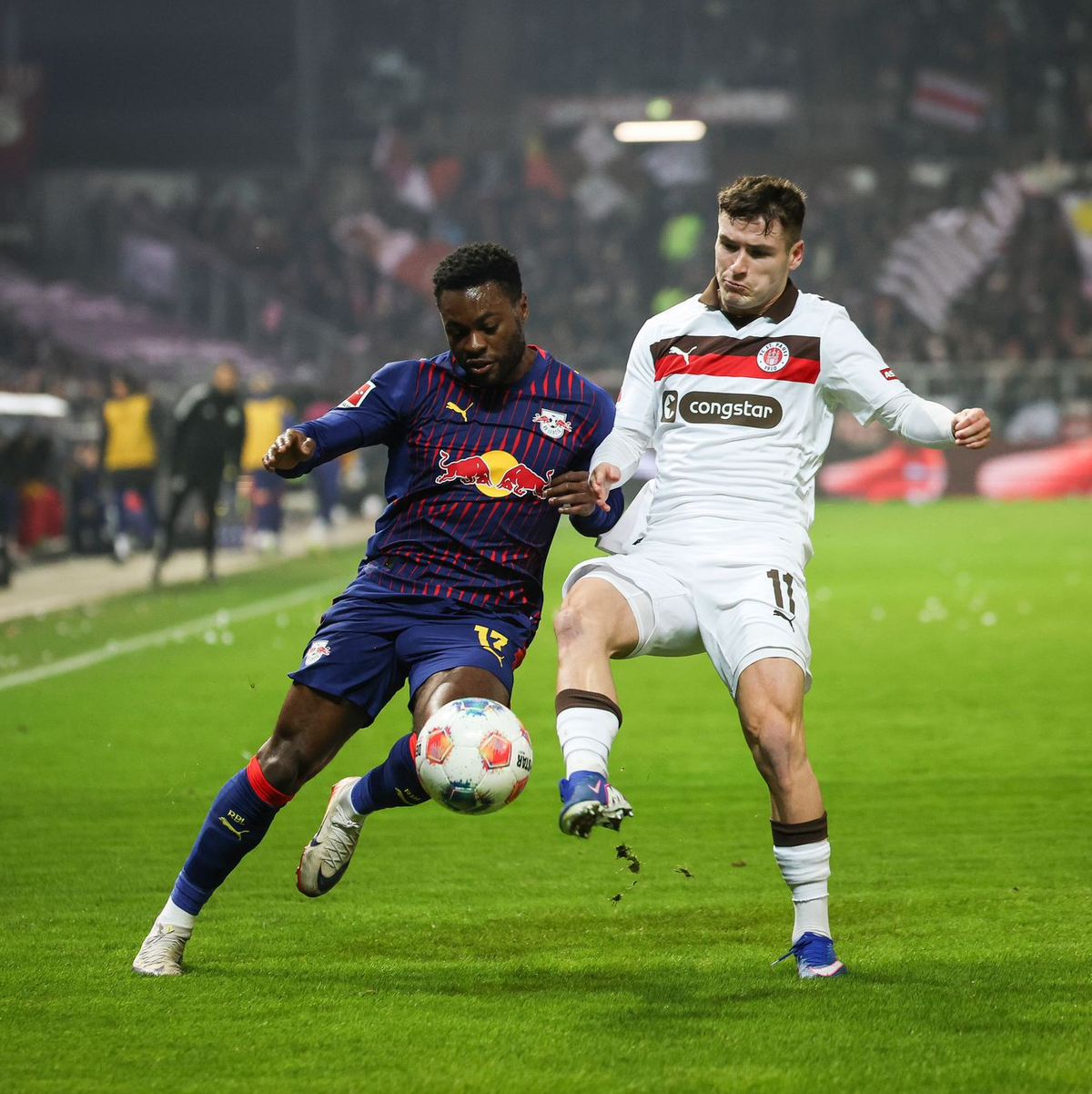 Leipzigs Ridle Baku (l) und St. Paulis Arkadiusz Pyrka kämpfen um den Ball. - Foto: Christian Charisius/dpa