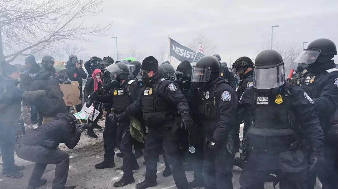 Bundesbeamte der Einwanderungsbehörde ICE sind hier bei einer Demonstration in Minneapolis zu sehen. - Bild: Adam Gray/AP/dpa