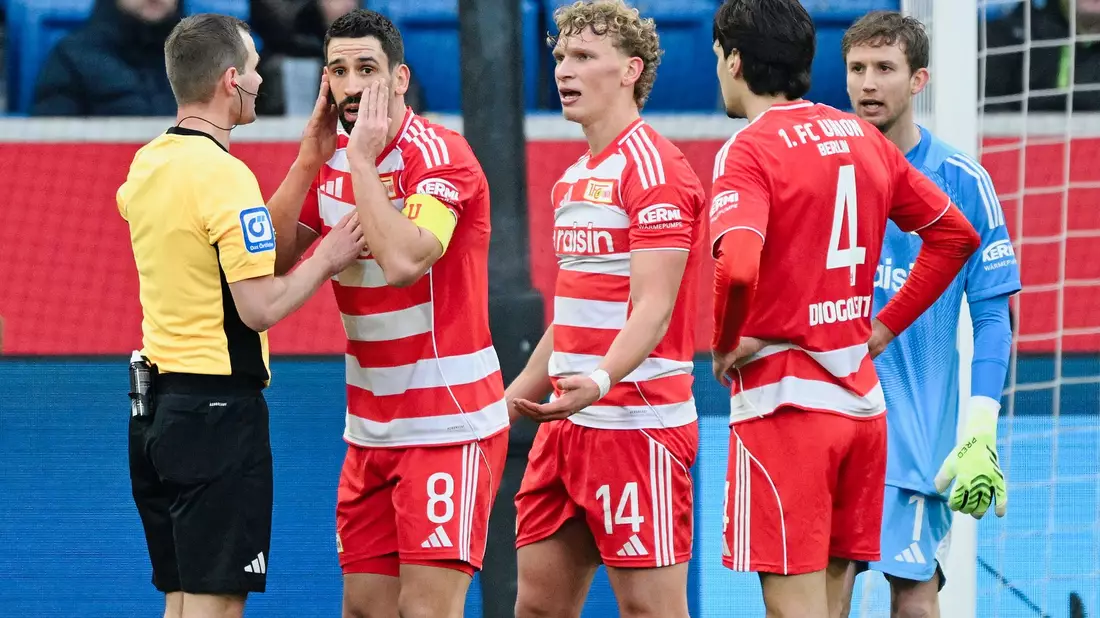 Union-Kapitän Rani Khedira (2.v.l.) : Bestürzt über den von Schiedsrichter Robin Braun gegebenen Elfer.   - Bild: Uwe Anspach/dpa