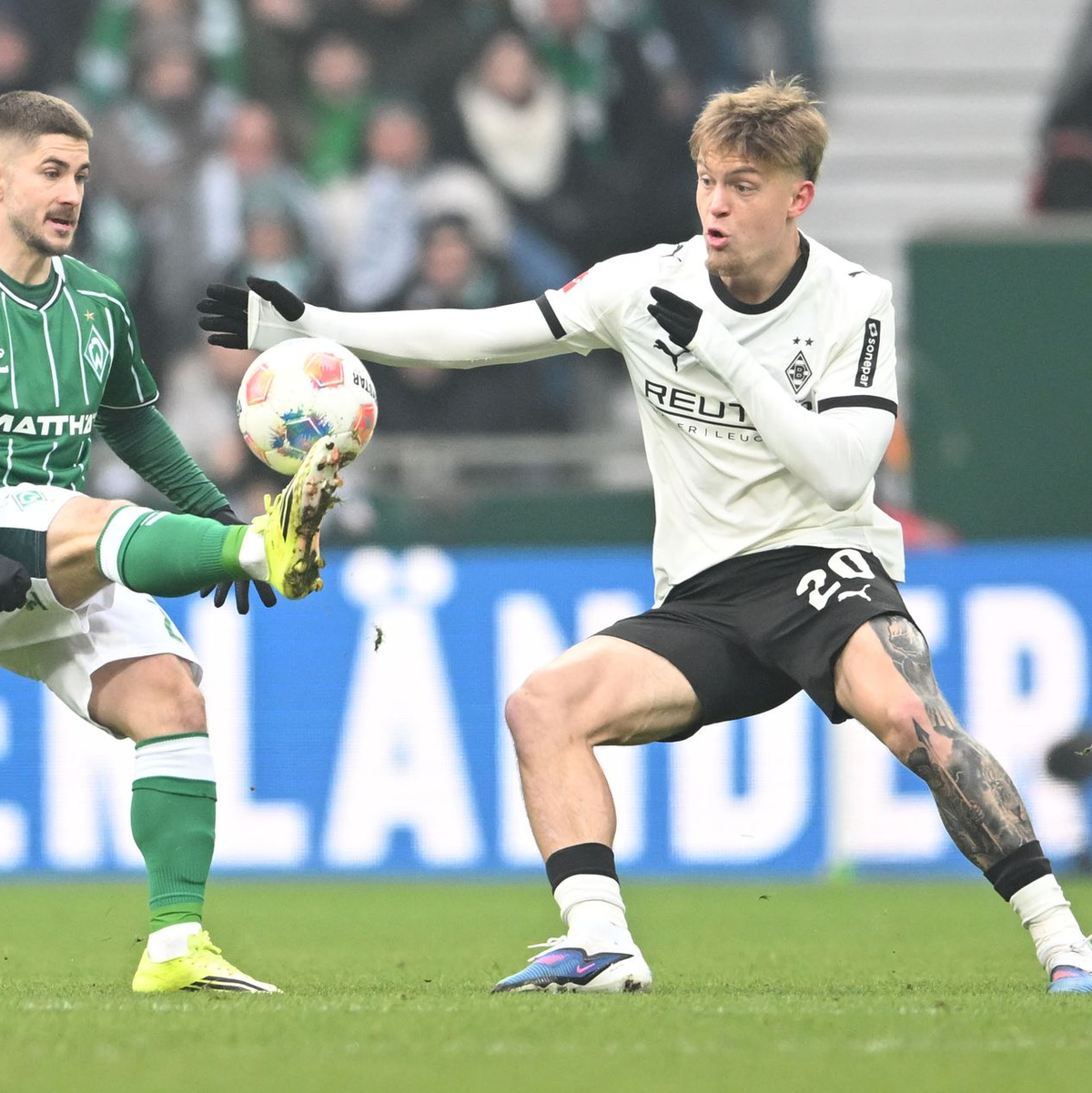 Werders Romano Schmid (l) wird vom Gladbacher Luca Netz gebremst. - Foto: Carmen Jaspersen/dpa