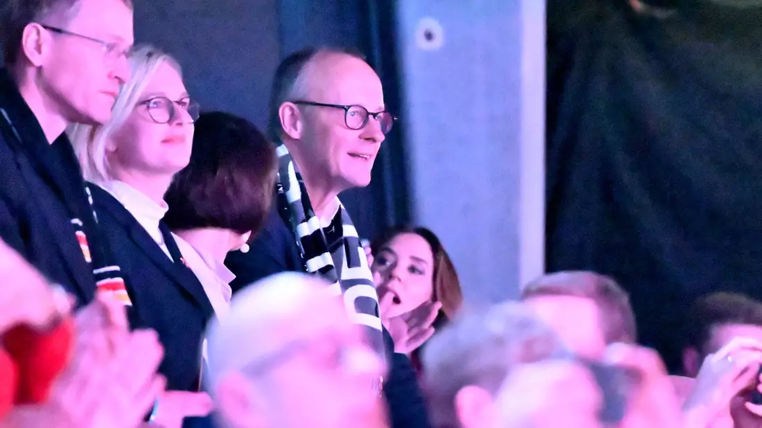 Drückte auf der Tribüne die Daumen: Bundeskanzler Friedrich Merz (r). - Bild: Sina Schuldt/dpa