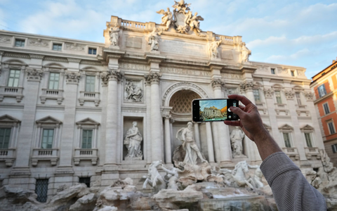 Ein Besucher macht ein Foto des Trevi-Brunnens. (Archivbild) - Foto: Andrew Medichini/AP/dpa