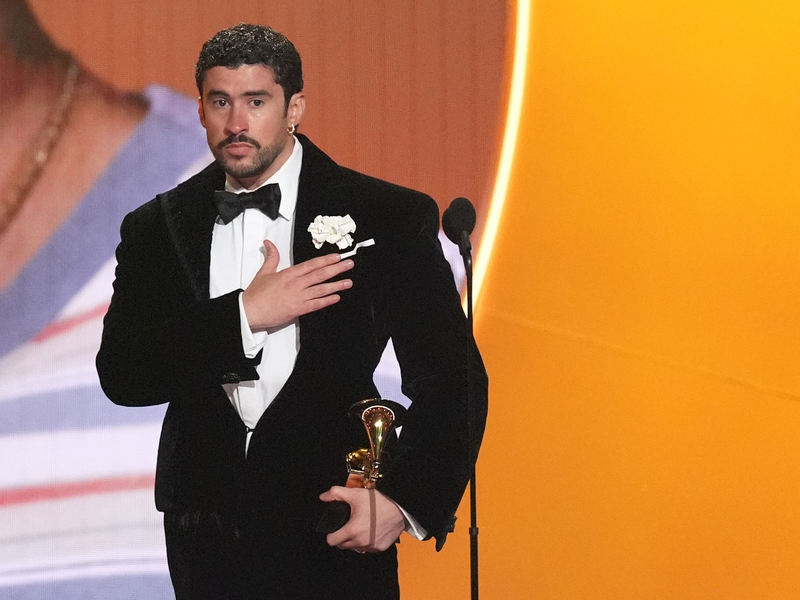 Bad Bunny nimmt den Preis für das Album des Jahres für «DeBÍ TiRAR MáS FOToS» bei den Grammy Awards entgegen ? und zeigt dabei, wo seine Heimat Puerto Rico liegt. (Archivbild) - Foto: Chris Pizzello/Invision/AP/dpa