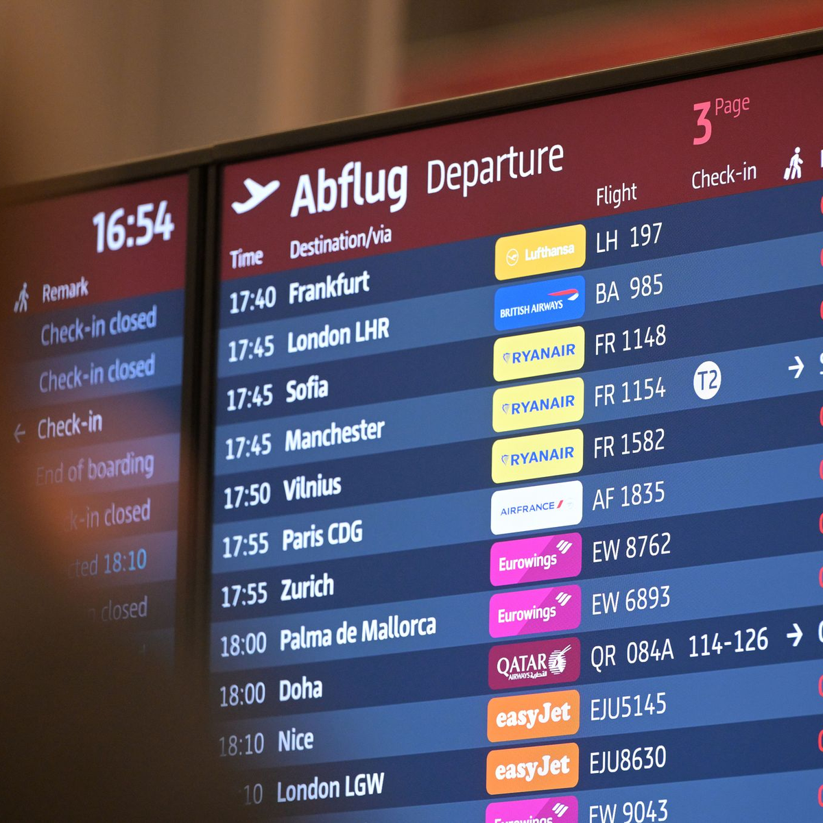Passagiere blicken auf eine Anzeigetafel am Hauptstadtflughafen BER. - Foto: Michael Bahlo/dpa